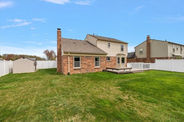 back of house with a deck, a yard, and a fenced backyard