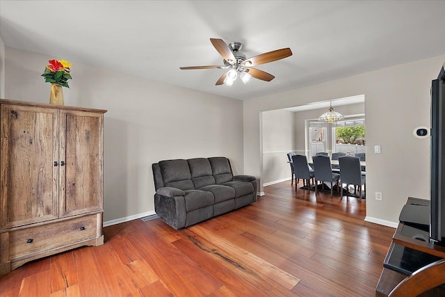 sitting room featuring visible vents, ceiling fan, hardwood / wood-style flooring, and baseboards