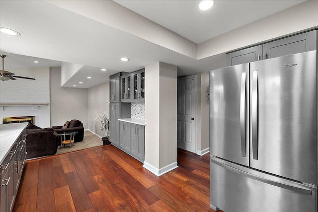 kitchen featuring gray cabinetry, light countertops, dark wood-type flooring, and freestanding refrigerator