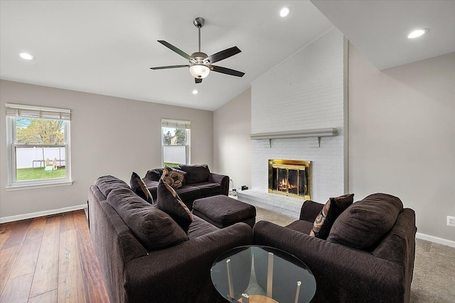 living area featuring lofted ceiling, ceiling fan, plenty of natural light, and baseboards