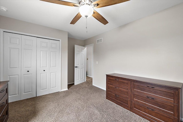 unfurnished bedroom with a closet, ceiling fan, visible vents, baseboards, and carpet floors