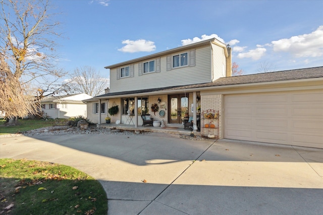 view of front of property with an attached garage, driveway, covered porch, and brick siding