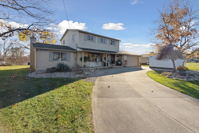 view of front of house with covered porch, a front lawn, brick siding, a chimney, and driveway