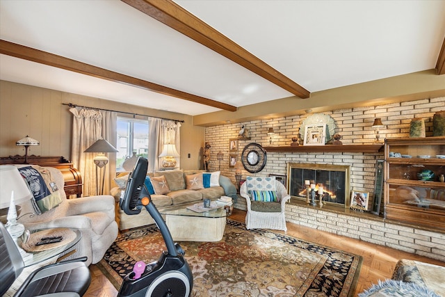 living area with brick wall, a brick fireplace, and beam ceiling
