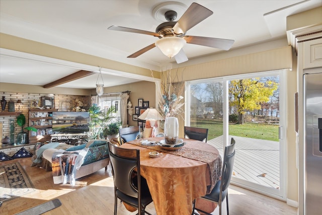 dining space with beamed ceiling, ceiling fan, and light wood finished floors