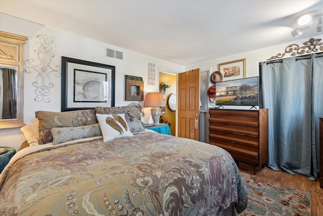 bedroom featuring visible vents and wood finished floors