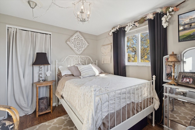 bedroom with an inviting chandelier and wood finished floors