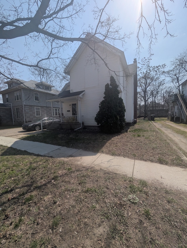 view of home's exterior featuring a chimney and covered porch