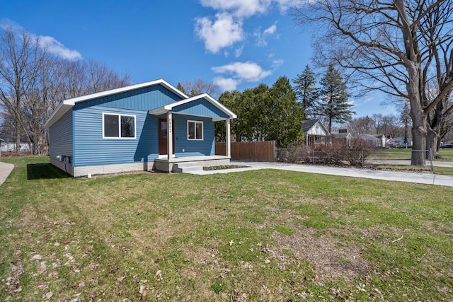view of front of property featuring a front yard, driveway, and fence