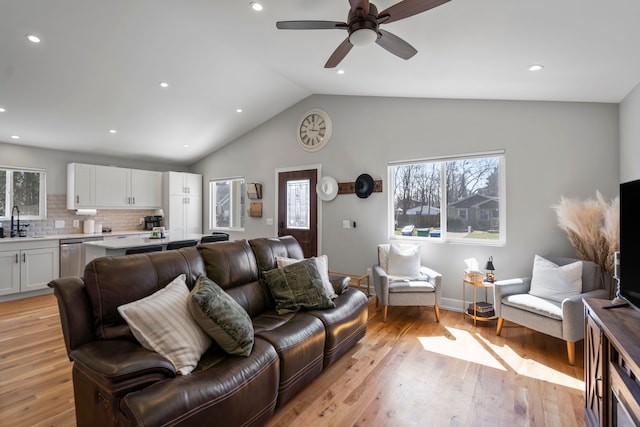 living area featuring light wood-style floors, ceiling fan, lofted ceiling, and recessed lighting