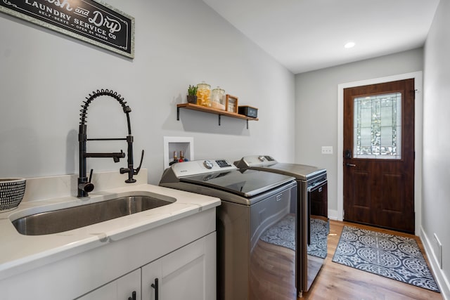 washroom featuring baseboards, washer and dryer, a sink, light wood-type flooring, and recessed lighting