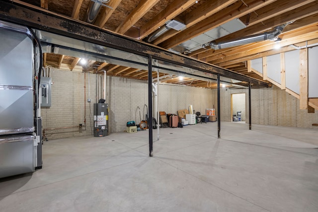 unfinished below grade area featuring brick wall, heating unit, and gas water heater