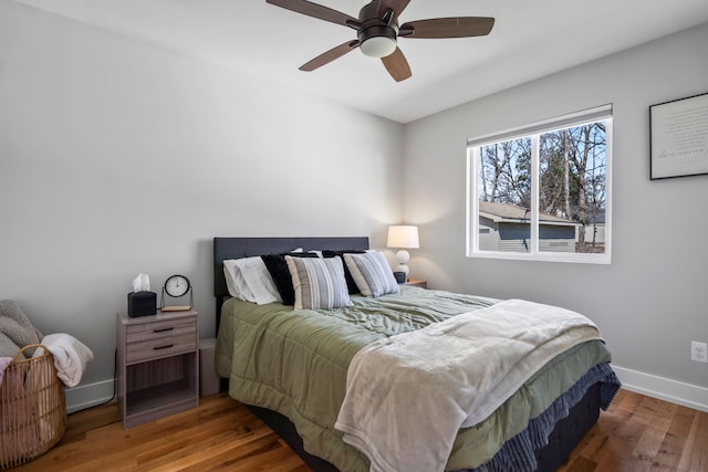 bedroom with baseboards, a ceiling fan, and wood finished floors