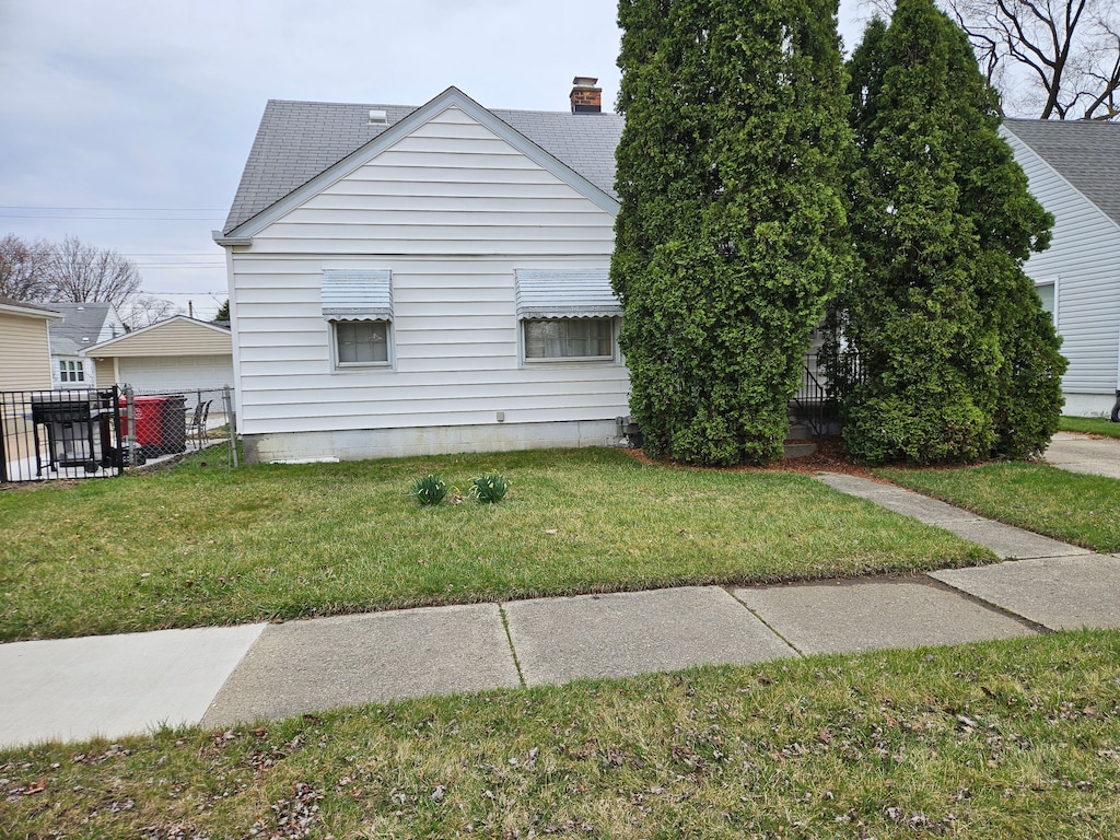 28120 Asmus St, Roseville, MI 48066 - view of side of property featuring roof with shingles, a yard, and fence