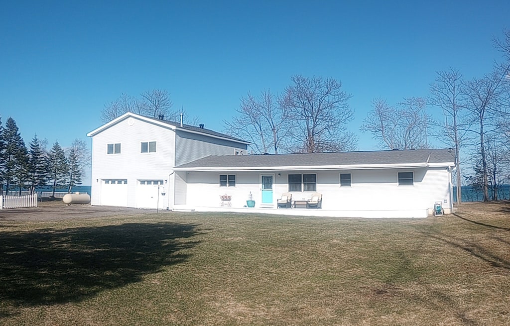7166 Lighthouse Rd, Port Hope, MI 48468 - back of house with a garage and a lawn