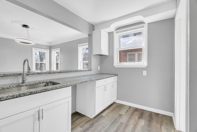 13955 Prevost St, Detroit, MI 48227 - kitchen featuring light wood-type flooring, a sink, white cabinetry, and light stone countertops