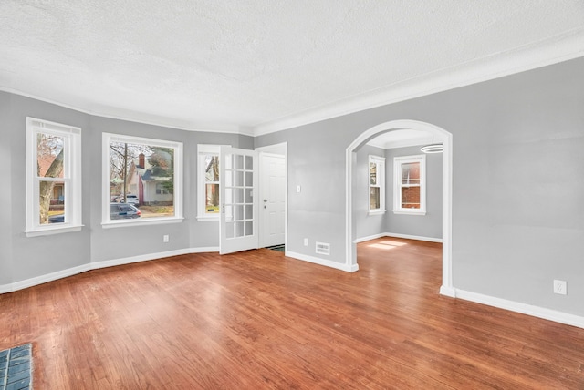 13955 Prevost St, Detroit, MI 48227 - unfurnished room featuring arched walkways, wood finished floors, baseboards, and a textured ceiling