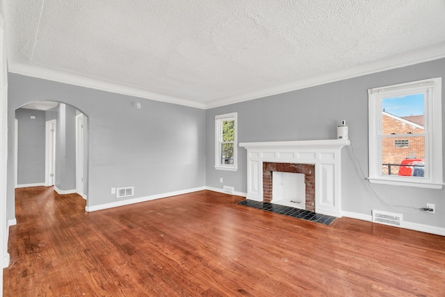 13955 Prevost St, Detroit, MI 48227 - unfurnished living room featuring visible vents, arched walkways, ornamental molding, wood finished floors, and a fireplace with flush hearth