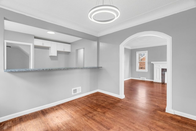 13955 Prevost St, Detroit, MI 48227 - spare room featuring visible vents, baseboards, arched walkways, and wood finished floors
