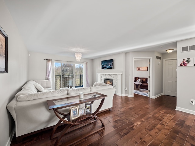 living room with visible vents, baseboards, dark wood-style floors, and a fireplace