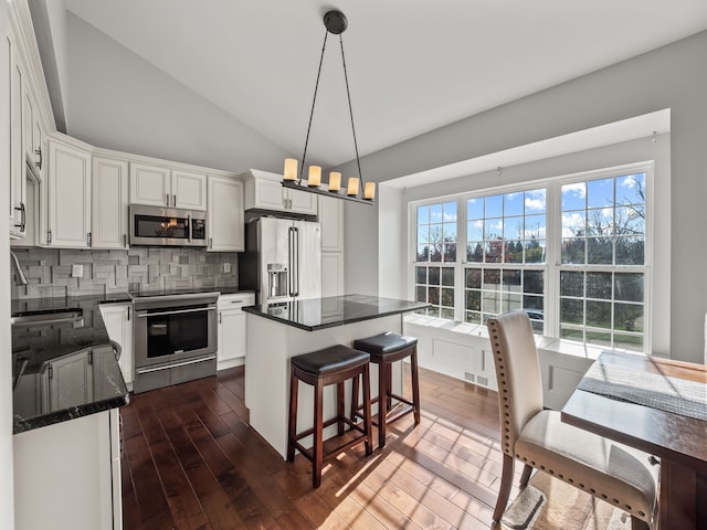 kitchen with tasteful backsplash, stainless steel appliances, dark wood-style floors, and white cabinets