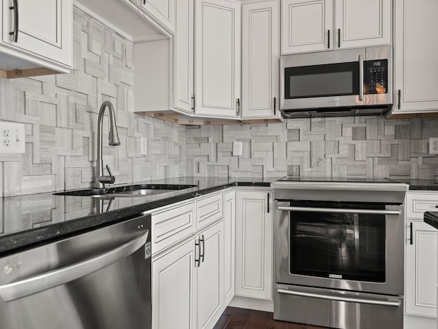kitchen featuring white cabinetry, appliances with stainless steel finishes, decorative backsplash, and a sink