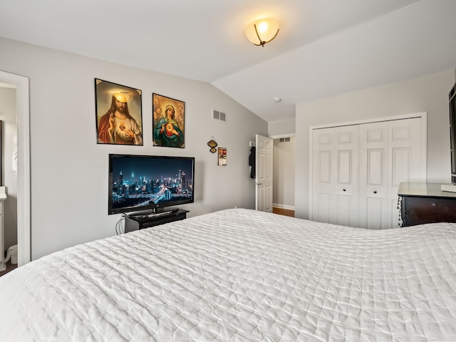 bedroom with baseboards, visible vents, vaulted ceiling, and a closet