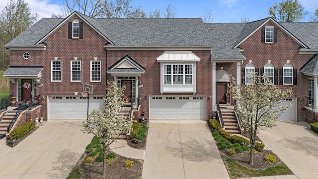 view of front of property with an attached garage, driveway, and brick siding