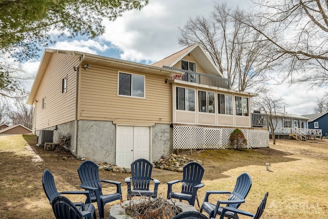 back of property featuring central air condition unit, a sunroom, and a balcony