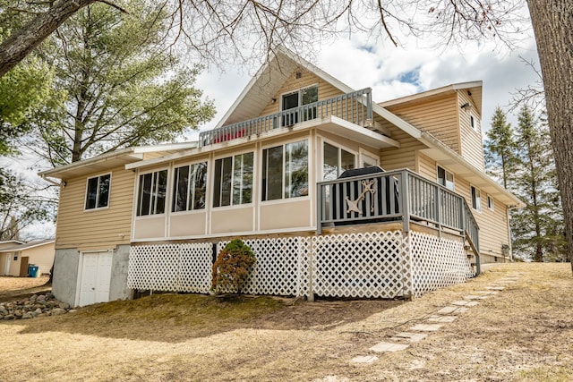 back of house with a sunroom and a balcony