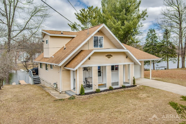 view of front facade with a front lawn, driveway, and roof with shingles