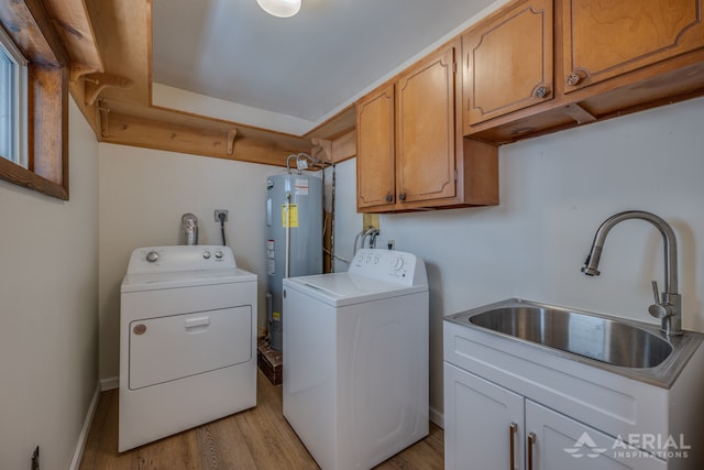 laundry room featuring light wood-style flooring, a sink, water heater, cabinet space, and washer and dryer
