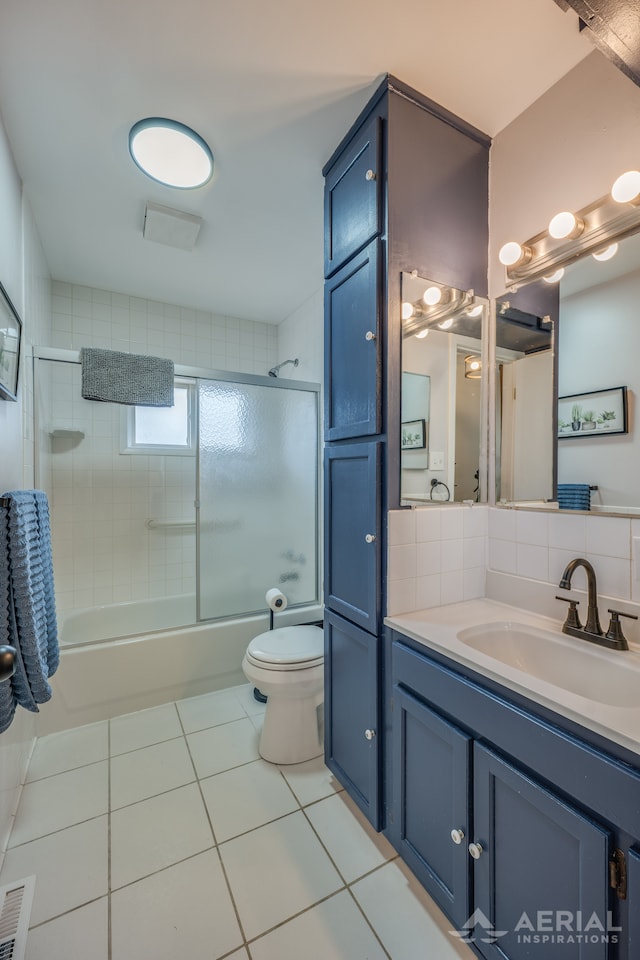 bathroom featuring tile patterned floors, vanity, shower / bath combination with glass door, toilet, and visible vents