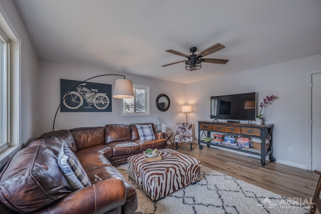 living room with baseboards, a ceiling fan, and wood finished floors