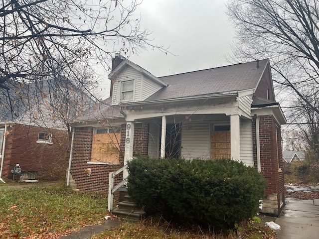 9166 Guilford St, Detroit, MI 48224 - view of home's exterior with a porch, a chimney, and brick siding