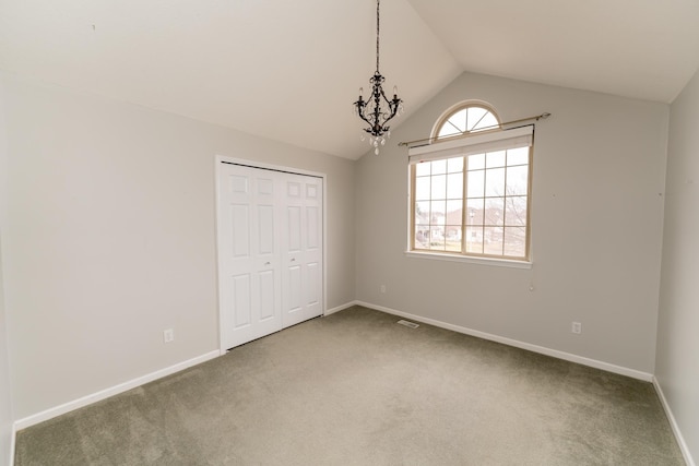 1527 Somerset Ct, Mount Pleasant, MI 48858 - unfurnished bedroom with a closet, baseboards, an inviting chandelier, carpet flooring, and lofted ceiling
