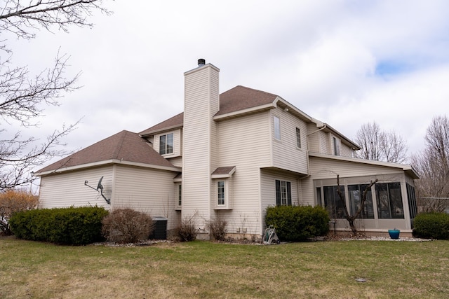 1527 Somerset Ct, Mount Pleasant, MI 48858 - rear view of house featuring a shingled roof, a sunroom, a lawn, and a chimney