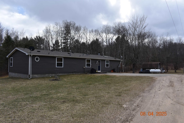 view of front of home with a front yard, driveway, and a detached carport