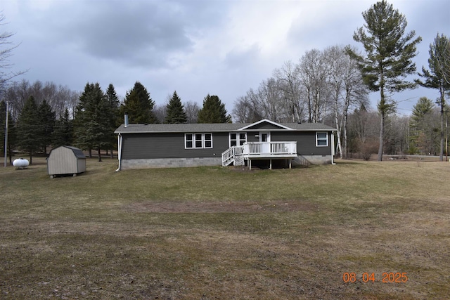 view of front of property featuring a front yard, a deck, a shed, crawl space, and an outbuilding