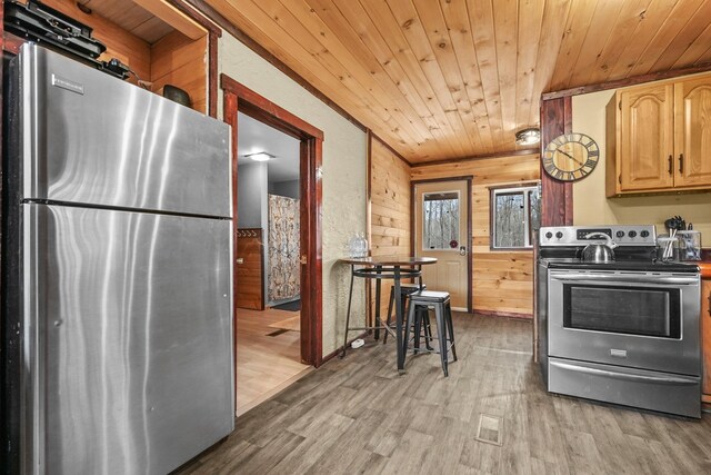 9341 W M-115, Mesick, MI 49668 - kitchen with light brown cabinets, light wood-style flooring, wood walls, appliances with stainless steel finishes, and wood ceiling