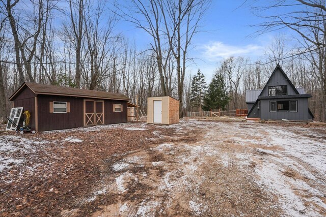 9341 W M-115, Mesick, MI 49668 - snowy yard featuring fence and an outbuilding