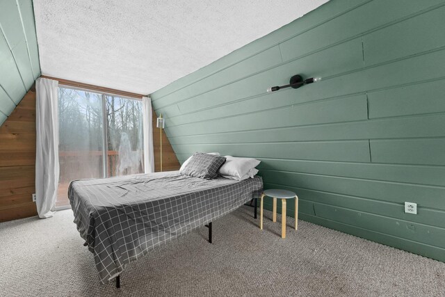 9341 W M-115, Mesick, MI 49668 - bedroom with wood walls, carpet, vaulted ceiling, and a textured ceiling