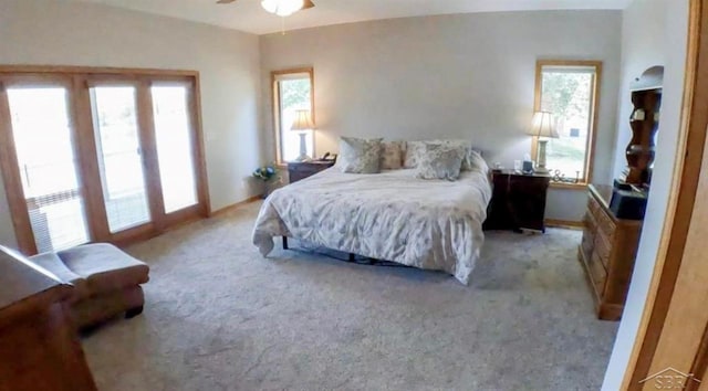 bedroom with baseboards, light colored carpet, and multiple windows