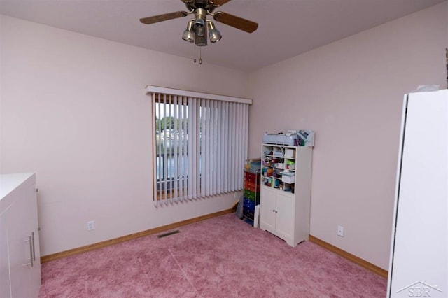 bedroom featuring visible vents, a ceiling fan, freestanding refrigerator, baseboards, and carpet flooring