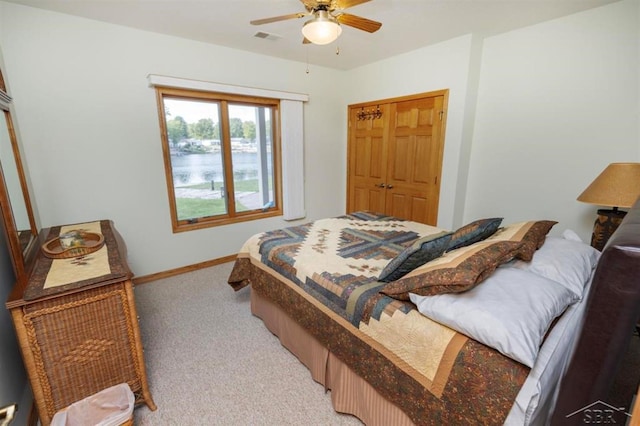 bedroom featuring light colored carpet, a ceiling fan, baseboards, visible vents, and a closet