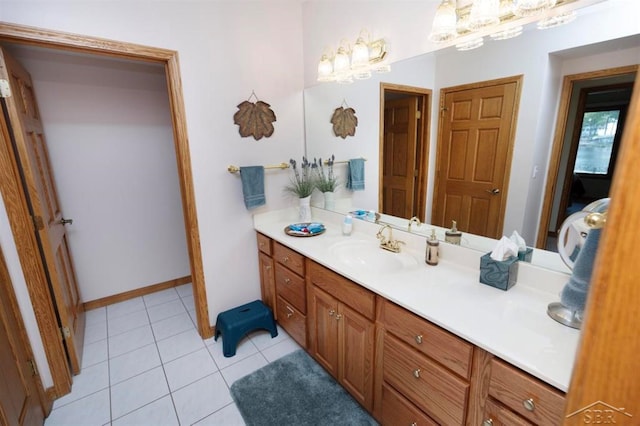 bathroom with baseboards, tile patterned flooring, and vanity