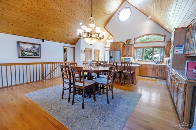 dining area featuring wooden ceiling, high vaulted ceiling, light wood finished floors, and a chandelier