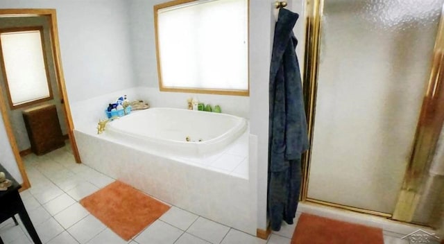 bathroom with a tub with jets, a shower stall, and tile patterned flooring