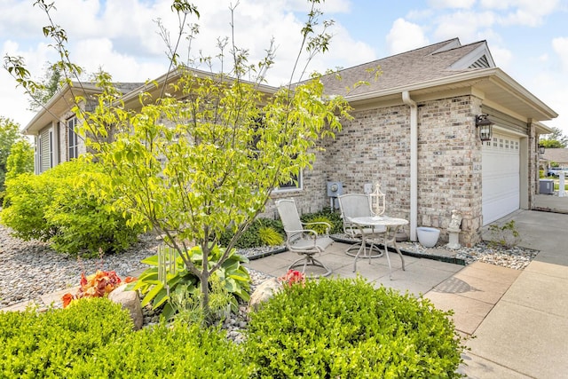 442 Constitution Ave, Brooklyn, MI 49230 - view of side of property with concrete driveway, roof with shingles, an attached garage, and brick siding
