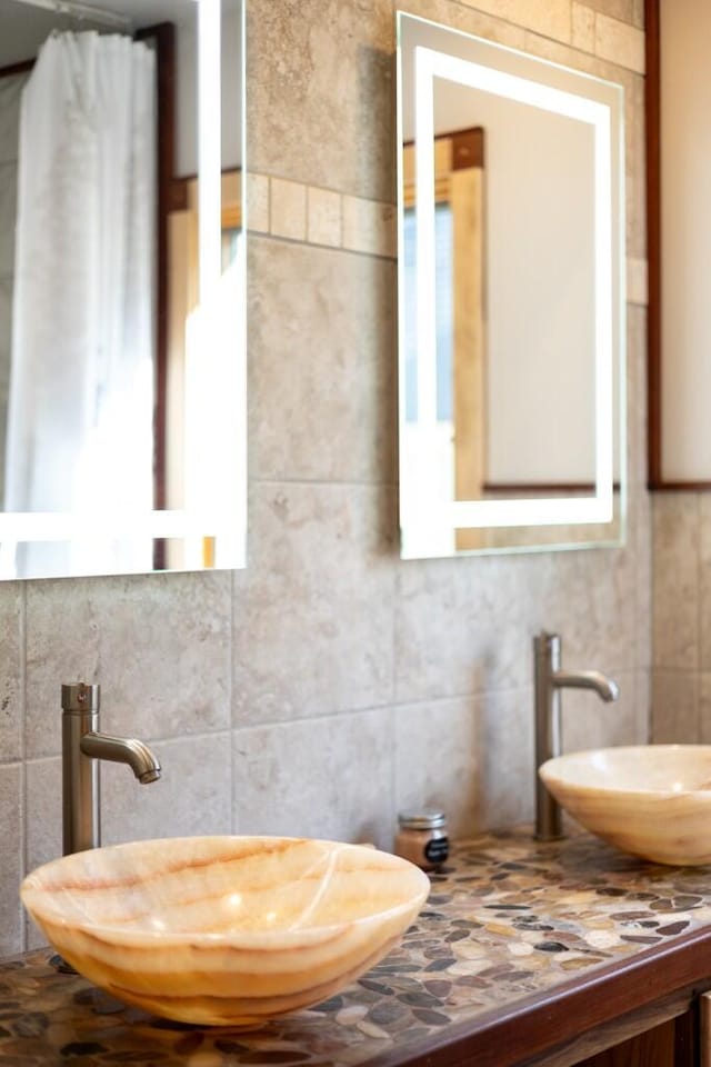 300 3rd St, Ann Arbor, MI 48103 - bathroom with tile walls, decorative backsplash, and a sink